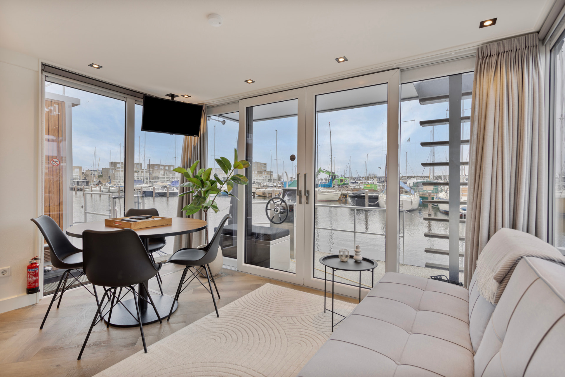 Woonkamer van Wordragen Houseboat Luxury met uitzicht over de jachthaven